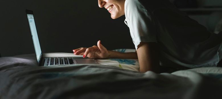 Woman using technolgy at night in the bedroom.