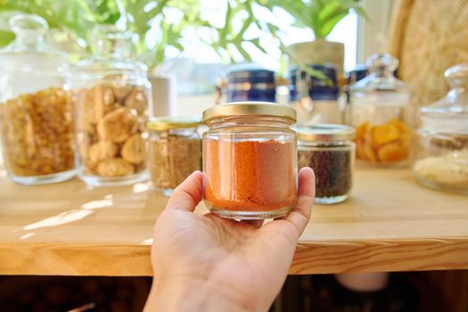 Jars with different spices in the kitchen, paprika close-up. Cooking at home, stocking food, household