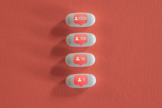 Still life of white pills with social media symbols.