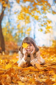 Children in the park with autumn leaves. Selective focus.