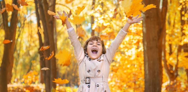 Children in the park with autumn leaves. Selective focus.