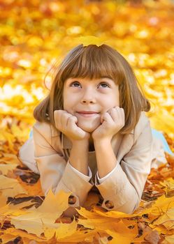 Children in the park with autumn leaves. Selective focus.