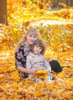 Daughter with mom in the autumn park. Selective focus.