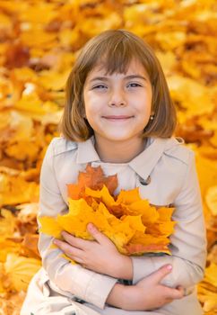 Children in the park with autumn leaves. Selective focus.