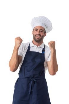 Portrait of happy young cook in uniform standing isolated over white background. Looking camera holding fists.