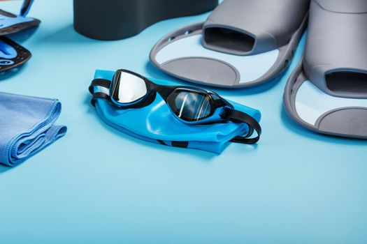 Sports equipment for swimming in the pool and open water on a blue background, close-up