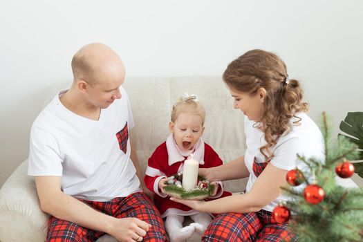 Baby child with hearing aid and cochlear implant having fun with parents in christmas room. Deaf and health