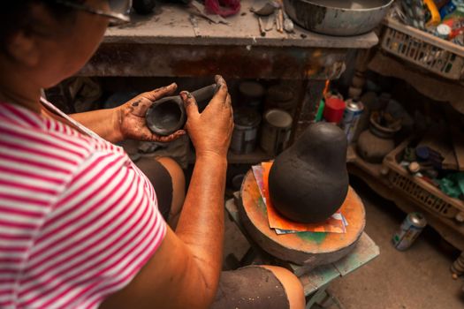 Closeup to the hands of a master craftswoman working a clay sculpture in La Paz Centro Nicaragua