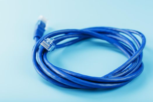 A coil of RJ45 Cat.6 Ethernet Network Internet Cable isolated on a blue background with free space
