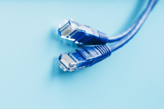 Blue Ethernet Cable Connectors Patch cord cord close-up isolated on a blue background with free space