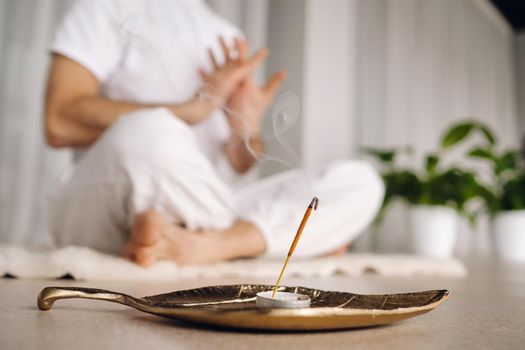 Close-up of a man in white sportswear doing yoga in a fitness room with a balgovon. the concept of a healthy lifestyle.