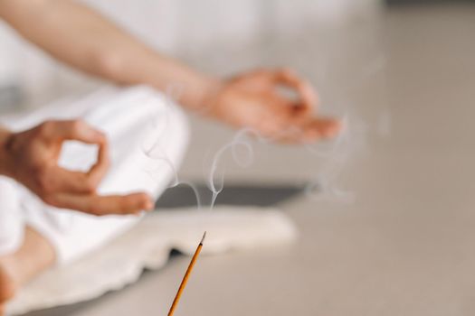 Close-up of a man in white sportswear doing yoga in a fitness room with a balgovon. the concept of a healthy lifestyle.