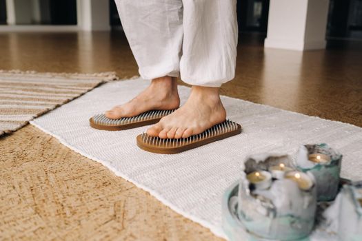 The man's feet are next to boards with nails. Yoga classes.