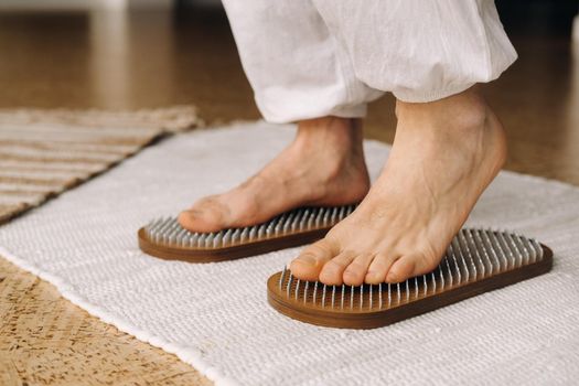 The man's feet are next to boards with nails. Yoga classes.