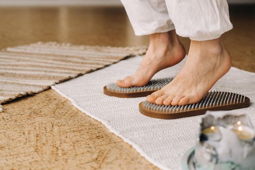 The man's feet are next to boards with nails. Yoga classes.