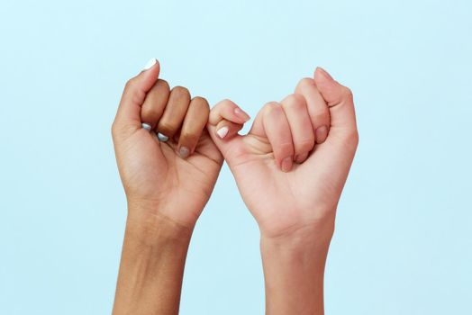 Stop racism. African and Caucasian hands gesturing on a blue studio background. Tolerance and equality, unity concept. Worldwide multiracial community