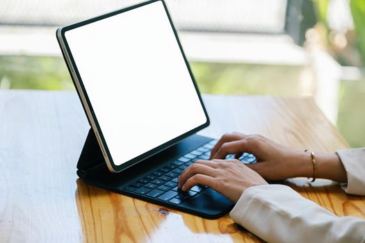 A woman using a tablet with a blank white screen. The blank space on the white screen can be used to write a message or place an image.