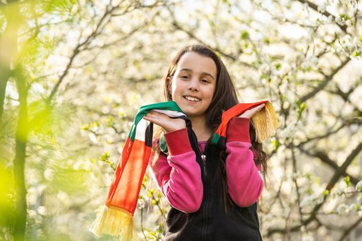 A little girl wearing an emirates flag ribbon.