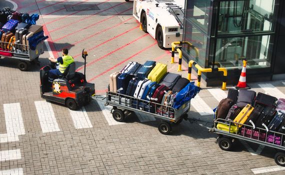 Motorised baggage cart carrying luggage at an airport runway