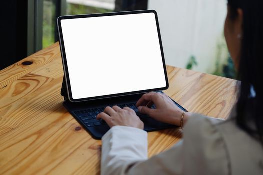 A woman using a tablet with a blank white screen. The blank space on the white screen can be used to write a message or place an image.