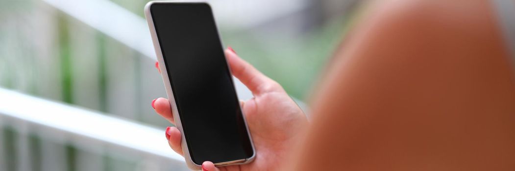 Woman holding a smartphone, hands close-up, blurry. Blank phone screen, mocap. Electronic device, touchscreen