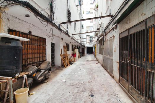 A narrow alley with high walls in a poor, marginalized part of downtown