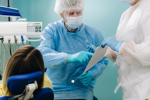 Dentist explaining the details of the X-ray to his patient in the office.