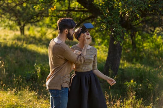 couple in nature, girl in virtual reality glasses close-up