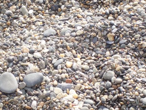 Background stones on the beach. Close up of rounded and polished beach rocks.