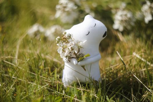 Eco-friendly cute handmade toy bear on grass at sunny summer day