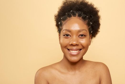 Beautiful woman with perfect skin looks at the camera. Portrait of a beautiful African American woman with fresh skin. Skin care, moisturizing