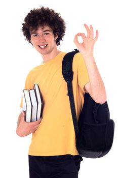 Smiling happy student standing with backpack and books and showing ok sign. Isolated on white.