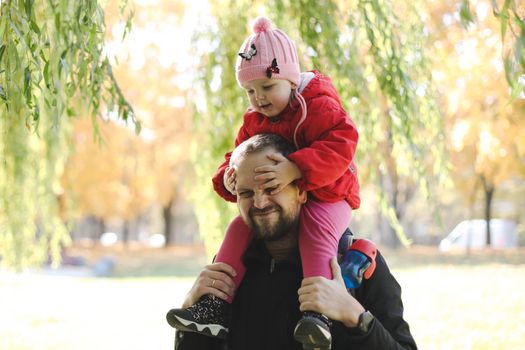 Happy father and child spending time outdoors. father with daughter in autumn park.