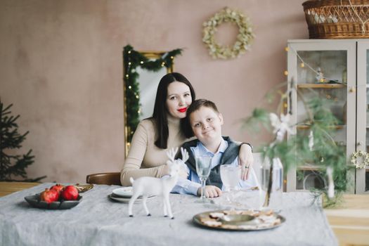 Happy family at home. Son with mom enjoying time together in a cozy room. Motherhood concept.