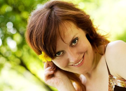 Portrait of a young smiling woman walking in the park.