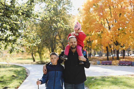 Happy father playing with his children outside in the park.