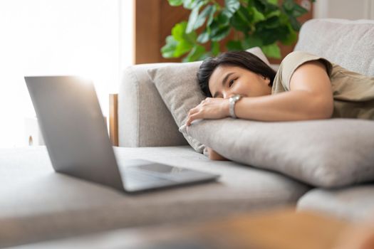 beauty asian woman watch video tv series on laptop computer happily on the bed at home.