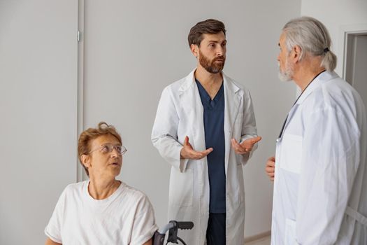 Professional doctors discuss over patient's diagnosis standing in hospital hall. High quality photo
