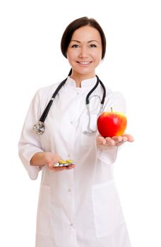 Female doctor holding apple and bunch of tablets isolated on white background