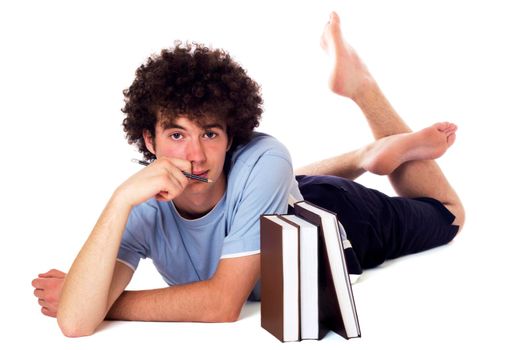 Pensive teenager with books lying on the floor and has downcast appearance. Isolated on white.