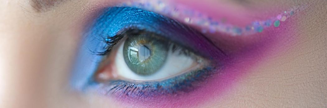 Bright blue eye makeup with sparkles. Stage makeup: basic rules and tips concept