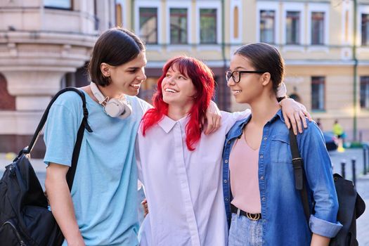 Happy smiling teenage friends hugging outdoor, on city street. Friendship, community, youth, lifestyle, leisure fun concept