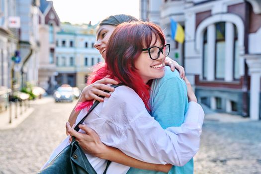 Meeting, hugging teenage male and female friends on the city street. Fashionable having fun teenagers guy and girl together. Friendship, communication, holidays, lifestyle, youth, urban style