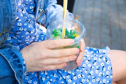 summer drink in female hands. cold mojito in a plastic glass. street non-alcoholic cocktail. High quality photo