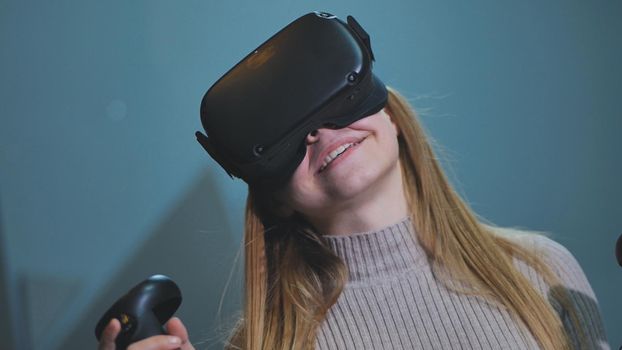 The girl plays virtual reality games in the club