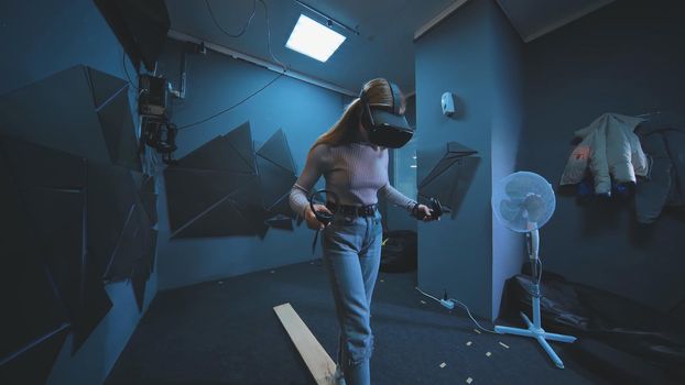 The girl plays a virtual reality game and walks on the board