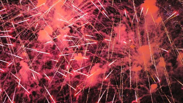 A colourful explosion of red fireworks in the night sky