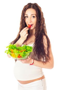 Pregnant woman eating chopped salad, isolated on white.