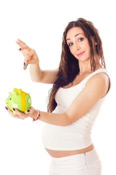 A woman putting money into a piggy bank in front of her pregnant belly. Isolated on white.