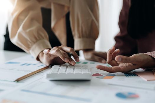 Close up of businessman or accountant hand holding pen working on calculator to calculate business data, accountancy document and laptop computer at office, business concept.